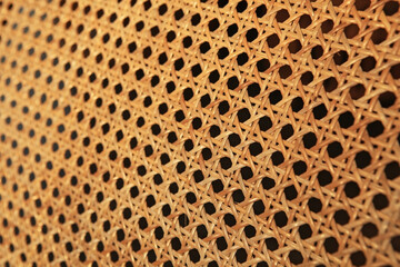 The backrest of a wooden chair that uses rattan woven by hand 