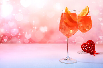 Festive alcoholic cocktail Aperol spritz in glasses and hearts, Valentine's Day concept, alcoholic drinks at party, bar and restaurant advertising, selective focus.
