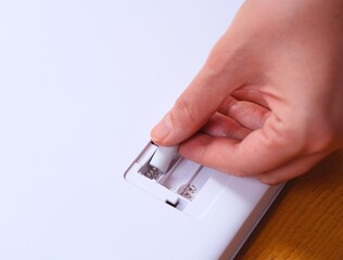 Woman hand placing batteries in to a device