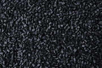 Fototapeta premium Pile of black plastic granules as background, top view
