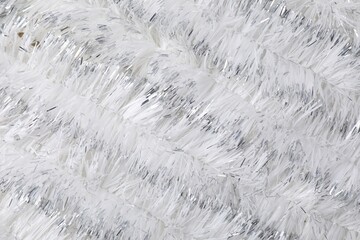 Shiny white tinsel as background, closeup view