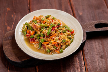 Couscous with vegetables in sauce on a plate on the table