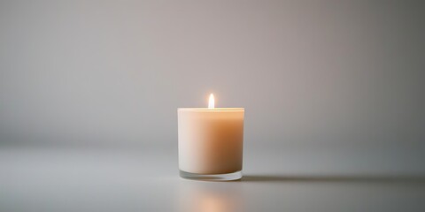 A single lit candle on a smooth surface, casting a warm glow against a neutral background, creating a calming atmosphere.
