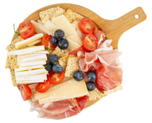 Charcuterie board. Wooden cutting board. Fruit and cheese platter. Cherry tomatoes and blueberries. Brie and parmesan cheese. Crackers and prosciutto. Sliced cheese and deli meat gourmet party snack. 