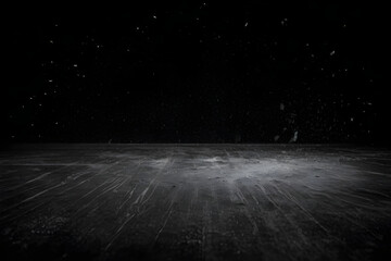 Dust particles floating over scratched black wooden surface on dark background