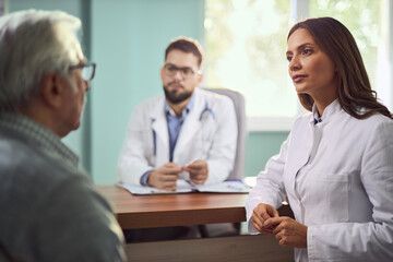 Female nurse talking to her senior patient at doctor's office.