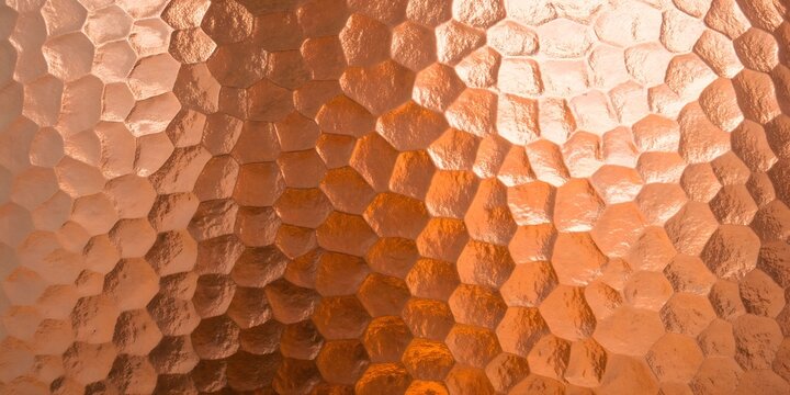 Close-up texture of hammered copper with hexagonal pattern for background or design