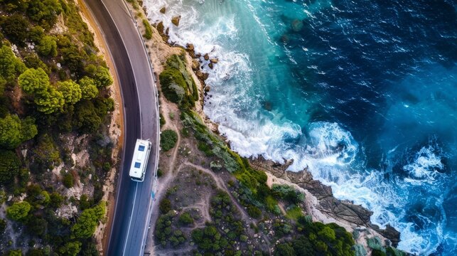 Empty area above a camper van traveling along a coastal road with crashing waves on a road trip