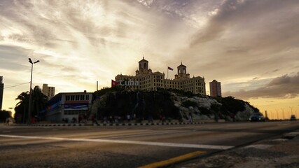 Sunset and a passing old car in Havana 