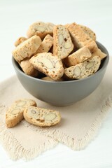 Traditional Italian almond biscuits (Cantucci) in bowl on white table, closeup