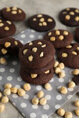 Tasty chocolate cookies with hazelnuts on table, closeup