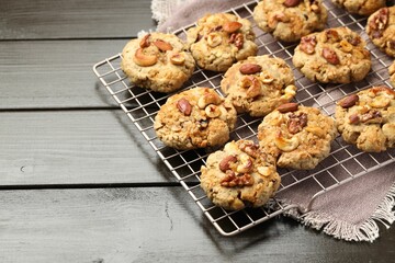 Tasty cookies with nuts on wooden table, closeup. Space for text