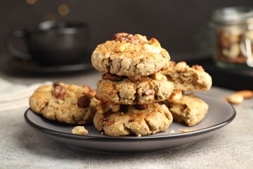 Tasty cookies with nuts on gray textured table, closeup