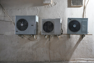 Old air conditioning external fan units on a wall, evening photo