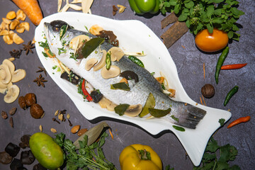 Steam Red Snapper with nim sauce served in tray dish isolated on grey background side view of Bangladeshi food