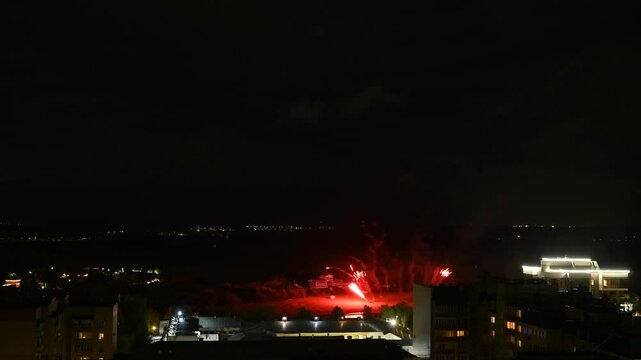 Timelapse video of fireworks in the night sky against the backdrop of an urban landscape.