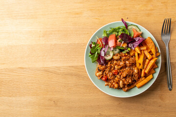 Chili con carne with sweet potato and salad, top view
