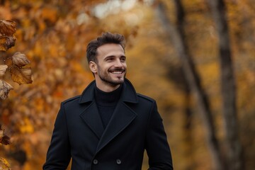 Photo of handsome smiling man in black coat in autumn scenery