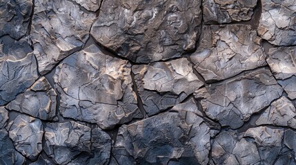 A wall made of rocks with a lot of cracks and holes. The wall is gray and brown in color