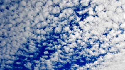 Blue sky and white Altocumulus clouds - abstract background with natural patterns of clouds. Topics: weather, air space, climate, atmosphere, meteorology, season, abstraction, nature, wallpaper