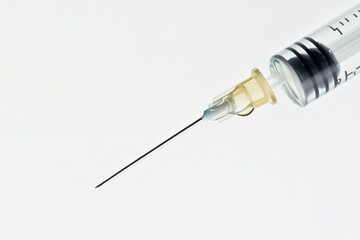 Syringe with sharp needle positioned against clean background, h