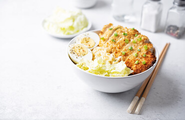 Ramen noodles with meat schnitzel slices, peking cabbage, eggs and scallions in a bowl