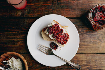 Bruschetta with cream cheese and sun-dried cheese on white plate