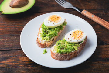 Toasts with mashed avocado, cream cheese and boiled egg