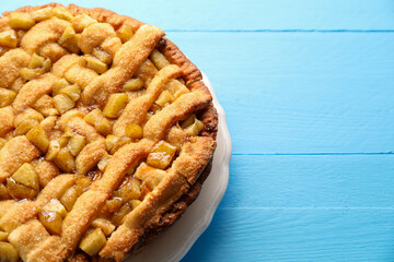 Tasty homemade apple pie on light blue wooden table. Space for text
