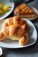 Fresh baked two buttered croissants served in restaurant for continental or French breakfast close up