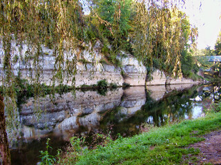 Rockface reflected in the Vezere river in the French village of St Leon sur Vezere