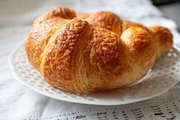 Fresh baked two buttered croissants served in restaurant for continental or French breakfast close up