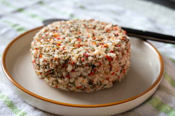 French cheese collection, fresh white soft goat cheese with aromatic herbs, garlic, parsley and red peppers close up