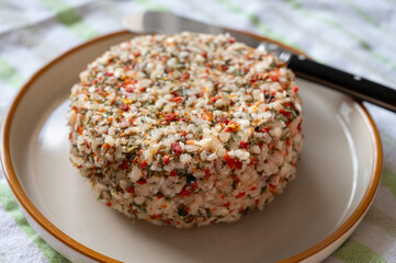 French cheese collection, fresh white soft goat cheese with aromatic herbs, garlic, parsley and red peppers close up