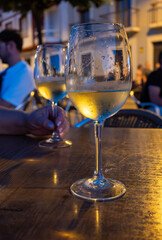 Obraz premium Two glasses of cold dry white wine served outdoor in cafe at night in historical Triana district, Sevilla, Spain, close up