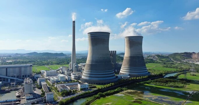 Aerial shot of steam rises from the huge chimneys of the operating power plant