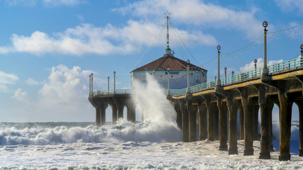 Large waves crash into the Manhattan Beach pier in Los Angeles, California during high surf advisory prompting authorities to close pier access.