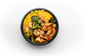 A top-down view of a Chinese takeout dish featuring shrimp in garlic sauce, served in disposable plastic bowl with fried rice and vegetables on white background