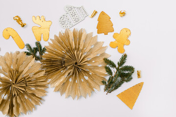 Christmas decoration flat lay, Christmas background. Paper golden garlands, handmade Christmas toys, fir branch, white background, copy space
