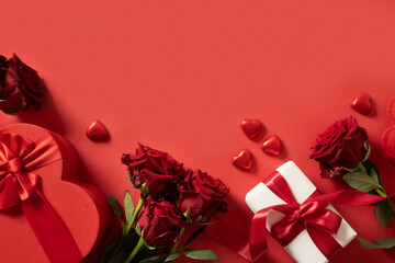 Valentine's day card with gift, hearts and red roses on red background. View from above. Copy space. Romantic date concept. Greeting card.