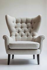 A beige chair with a buttoned back and wooden legs