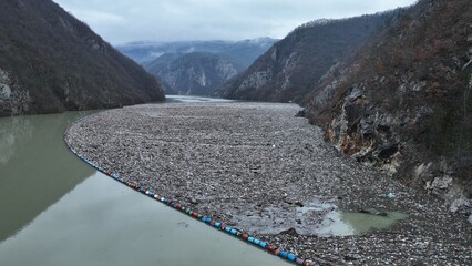 Dirty river, polluted with waste, destroyed environment and nature, plastic and tires
