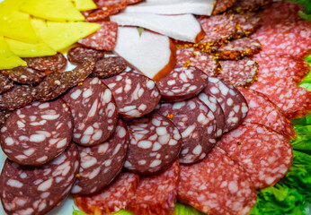 Selection of assorted meats and cheeses displayed on a platter at a gathering