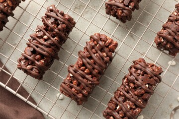 Delicious chocolate puffed rice bars on gray textured table, top view
