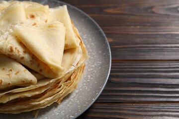 Tasty crepes on wooden table, closeup. Space for text