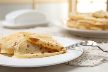 Tasty crepes on white wooden table, closeup