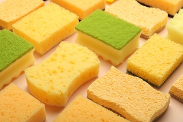 Many colorful sponges on beige background, closeup