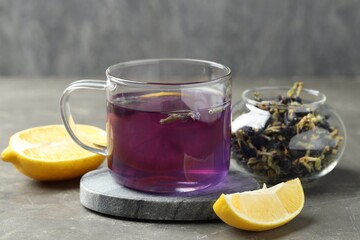 Delicious butterfly pea flower tea with lemon on gray textured table