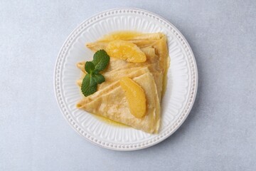Delicious Crepes Suzette on light table, top view