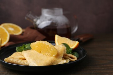Delicious Crepes Suzette on wooden table, closeup